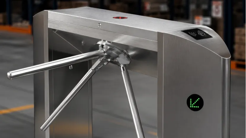 Close-up of a stainless steel tripod turnstile in an industrial warehouse