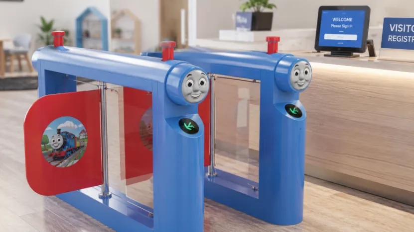 Train-themed preschool turnstile near a visitor registration desk